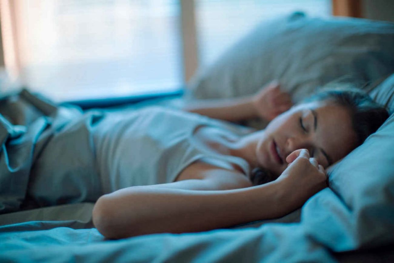 Kvinna som sover i en säng