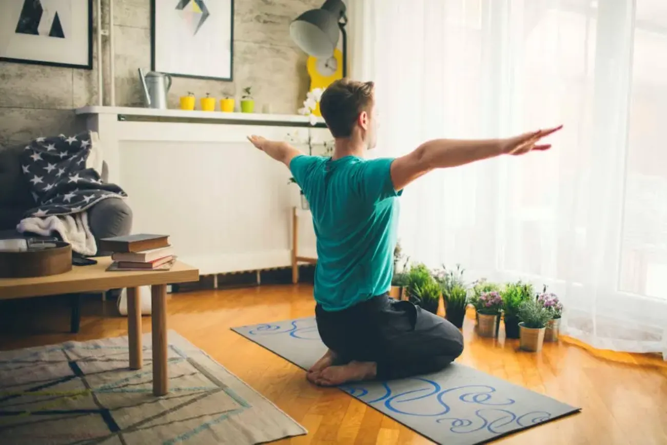Man tränar hemma på yogamatta