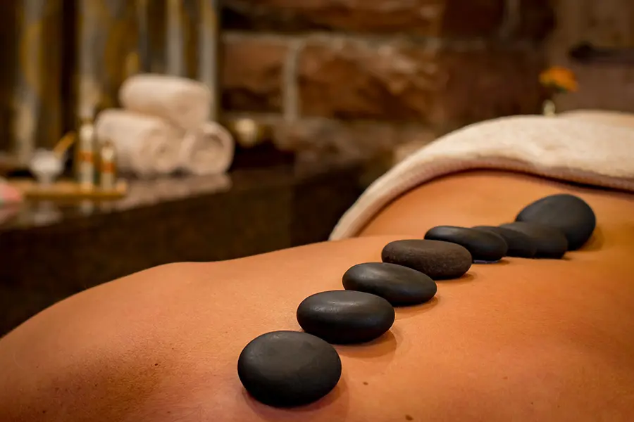Svarta spa-stenar på en persons rygg