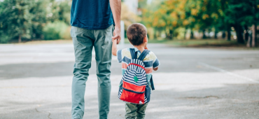 En förälder går hand i hand med sin son